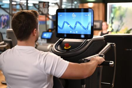 Eine digitalisierte Ruderbank in einem Fitnessstudio, auf deren Display der Nutzer mit seiner Kraftanstrengung eine Figur eines Computerspiel steuert: Solche Daten könnten für eine Trainingsanalyse ausgewertet werden.
