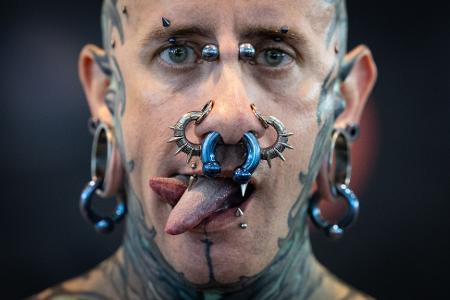 Andrew aus Spanien präsentiert Tattoos, Piercing und eine gespaltene Zunge auf der Tattoo Convention in Frankfurt.