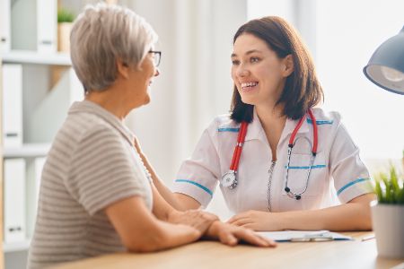 Ältere Frau unterhält sich mit Ärztin