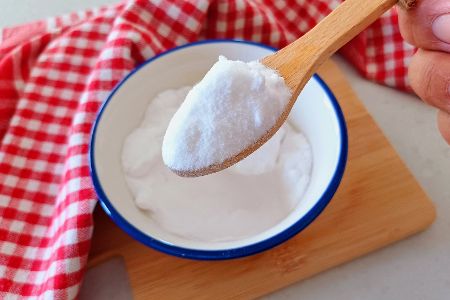 Schüssel mit Natron, Löffel und rot karierter Decke