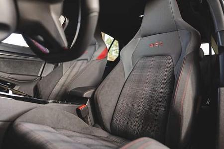 Detailaufnahme der Sportsitze im VW Golf GTI, Modelljahr RG25, mit charakteristischer GTI-Stickerei und Karomuster.