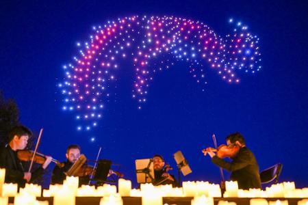 Sychronisierte Drohnen formen bei einer DroneArt Show Lichtbilder am Himmel über den Gärten der Welt in Berlin.