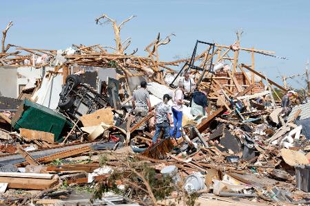 Eine Familie blickt nach einem Tornado durch die Trümmer ihres Hauses im Stadtteil Grayridge in Oklahoma.