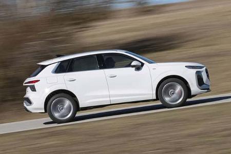 Audi Q3 SUV TFSI quattro in weißer Lackierung, seitlich fahrend auf Landstraße, unscharfer Hintergrund durch Mitzieheffekt.