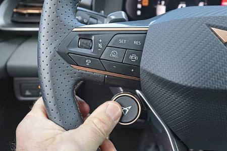 Detailaufnahme des Lenkrads eines Cupra Terramar 2.0TSI 4Drive mit Bedientasten und Daumen am Mode-Button.