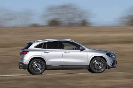 Mercedes GLA250 4Matic fährt auf einer Landstraße, Seitenansicht, silberfarbenes Kompakt-SUV.