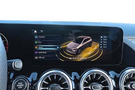 Das Bild zeigt das digitale Cockpit eines Mercedes GLA250 4Matic mit Anzeige der Fahrmodi auf dem zentralen Display. Zu sehen sind die Auswahlmöglichkeiten Comfort, Eco, Sport, Individual und Offroad sowie eine 3D-Visualisierung des Fahrzeugs.