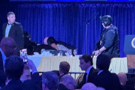 Gäste am Ehrentisch werden in Sicherheit gebracht.