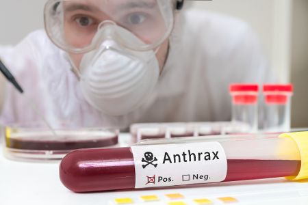 Forscherin in Schutzkleidung mit Anthrax-Blutprobe