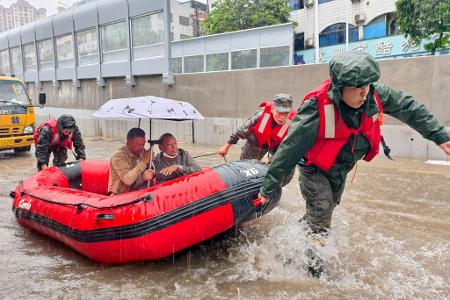 Retter helfen mit Schlauchbooten nach den starken Regenfällen in Qinzhou.