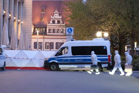 Kriminaltechniker gehen zum Tatfahrzeug. 