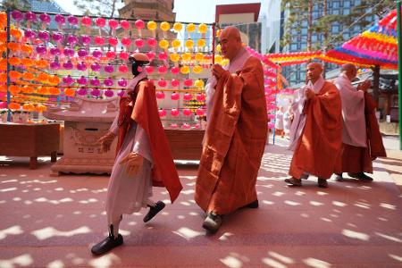 Ein Roboter und buddhistische Mönche umrunden zusammen eine Pagode während einer Zeremonie vor dem Geburtstag Buddhas im koreanischen Seoul.
