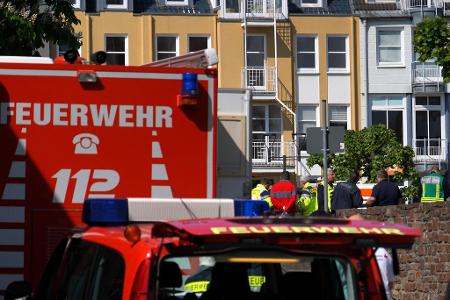 Rettungswagen, Polizisten und Polizeifahrzeuge stehen in der Nähe des Einsatzortes.