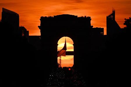 Die französische Nationalflagge weht unter dem Arc de Triomphe auf der Avenue des Champs Elysees während des sogenannten "Paris Henge"-Phänomens.