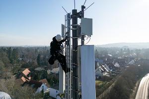 Ein Telekom-Techniker an einem Mobilfunk-Masten - an so einem Standort könnten künftig auch Anti-Drohnen-Sensoren hängen. (Archivbild)