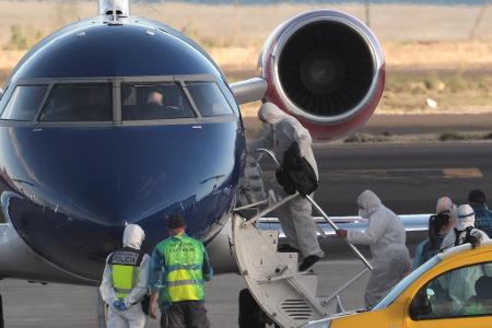 Die Passagiere betraten in Schutzkleidung das Flugzeug. 