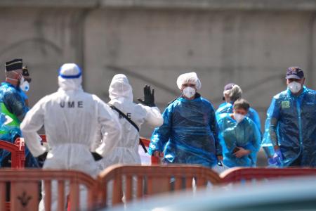 Person in Schutzbekleidung und mit Masken (r) gehen im Hafen von Granadilla auf Teneriffa an Land.