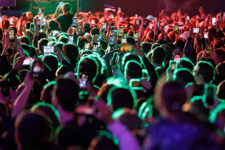 Musikfans feiern im Eurovision Village in Wien vor dem Historischen Rathaus bei einem Konzert. 