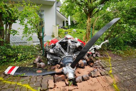 Ein Propeller der Maschine liegt vor einem Wohnhaus.