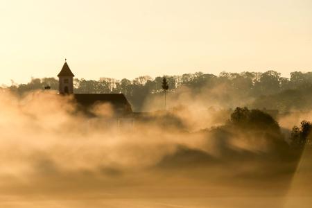 Vom Nebel umhüllt: die Kirche Sankt Gallus am Morgen kurz nach Sonnenaufgang.