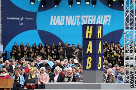 Das Motto des Katholikentags ist auf einer Bühne zu sehen. 