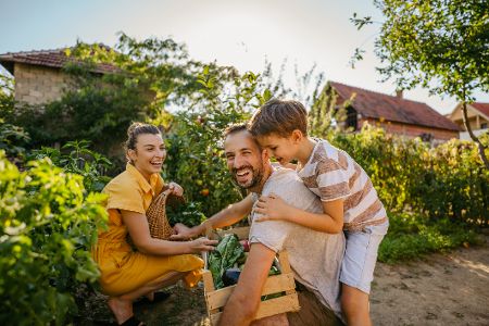 Familie fröhlich im Garten beim Ernten