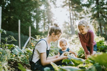 Mutter mit zwei kleinen Kindern im Garten