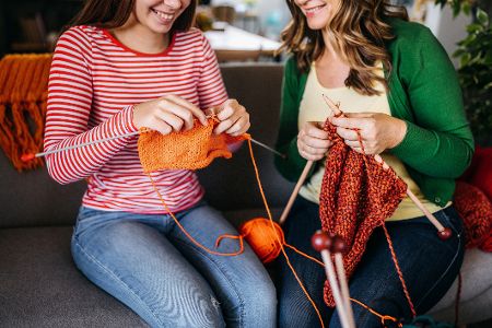 Zwei junge Frauen sitzen zusammen und stricken