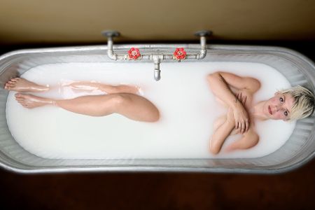 Frau in einer Badewanne gefüllt mit Milch