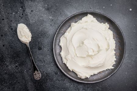 Quark in einer Schüssel mit Löffel daneben