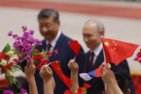 Mit Blumen und Fähnchen empfingen chinesische Kinder den Gast aus Moskau. 