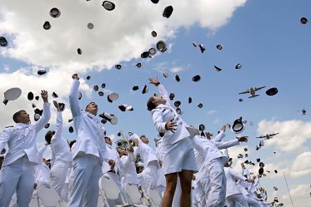 Neue ernannte Fähnriche werfen ihre Mützen zum Abschluss der Feierlichkeiten an der United States Coast Guard Academy in New London.
