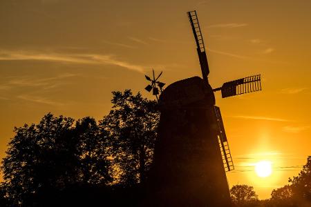 Die Sonne geht hinter der Turmholländermühle in Dörrwalde unter. 