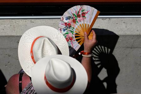 Zuschauer kühlen sich an einem heißen Tag mit Handfächern bei den Tennis French Open.
