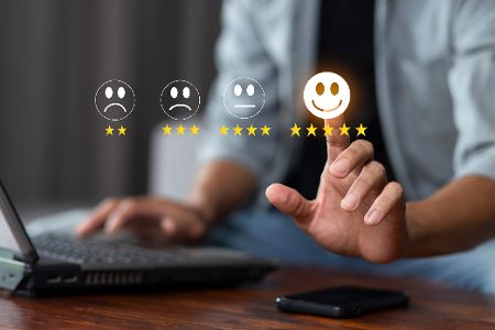 Person am Laptop bewertet online etwas sehr positiv