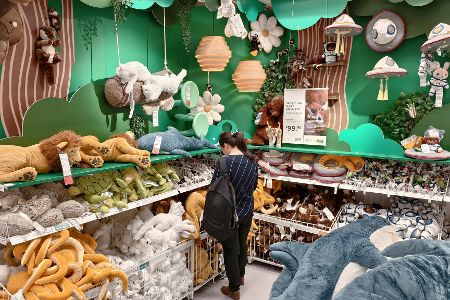 Frau steht alleine vor den Stofftierregalen von Ikea