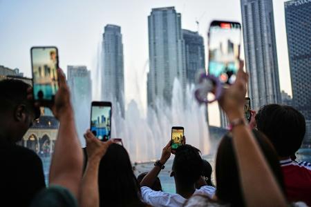 Eid al-Adha in Dubai: Besucher fotografieren den Brunnen vor der Skyline