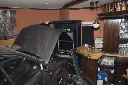 Ein PKW steht nach einem Unfall vor einer Kneipen-Bar.