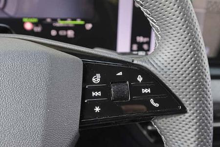 Detailaufnahme des Multifunktionslenkrads eines Audi Q6 SUV e-tron quattro mit Bedientasten für Heizung, Telefon, Sprachsteuerung und Mediensteuerung.