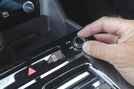 Detailaufnahme des Bedienfelds im Innenraum eines Audi Q6 SUV e-tron quattro mit Hand am Drehregler.