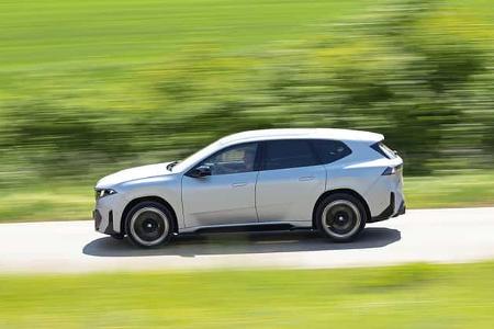 BMW IS 30x drive SUV fährt auf einer Landstraße, Seitenansicht, dynamische Bewegungsunschärfe, grüne Landschaft.