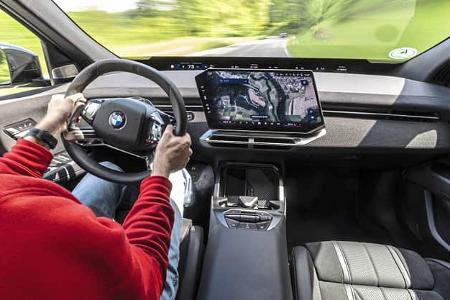 Innenraumaufnahme eines BMW IS 30x drive mit Fokus auf das Cockpit, Lenkrad und das zentrale Infotainmentsystem während der Fahrt.