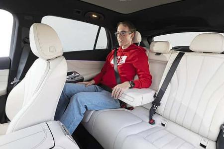 Innenraumaufnahme eines Mercedes GLC 400 4matic EQ mit einer Person auf der Rückbank, helle Lederausstattung.