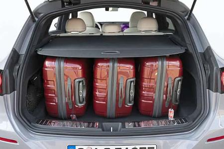 Mercedes GLC 400 4matic EQ, Kofferraumansicht mit drei roten Koffern, aufgenommen von hinten, Nummernschild sichtbar.