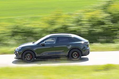 Porsche Macan 4S fährt auf einer Landstraße, Seitenansicht, grüne Landschaft im Hintergrund, Bewegungsunschärfe.