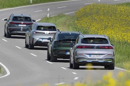 Vier aktuelle Elektro-SUVs (BMW i5 30xDrive, Mercedes GLC 400 4MATIC EQ, Audi Q6 SUV e-tron quattro, Porsche Macan 4S) fahren auf einer Landstraße im Konvoi.