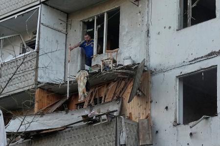 Ein Mann räumt in Kiew Trümmer an seinem Wohnhaus raus, das nach einem russischen Raketeneinschlag beschädigt wurde.