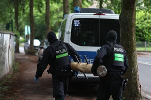 Polizisten tragen einen Rammbock.