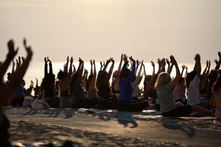Hunderte Menschen nehmen an einer öffentlichen Yoga-Stunde am frühen Morgen am „Oak Street Beach“ am Lake Michigan teil. 
