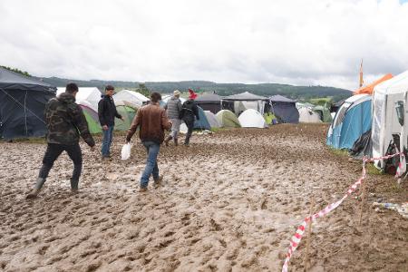 Rock am Ring: Camper waten nach Regen durch den Schlamm